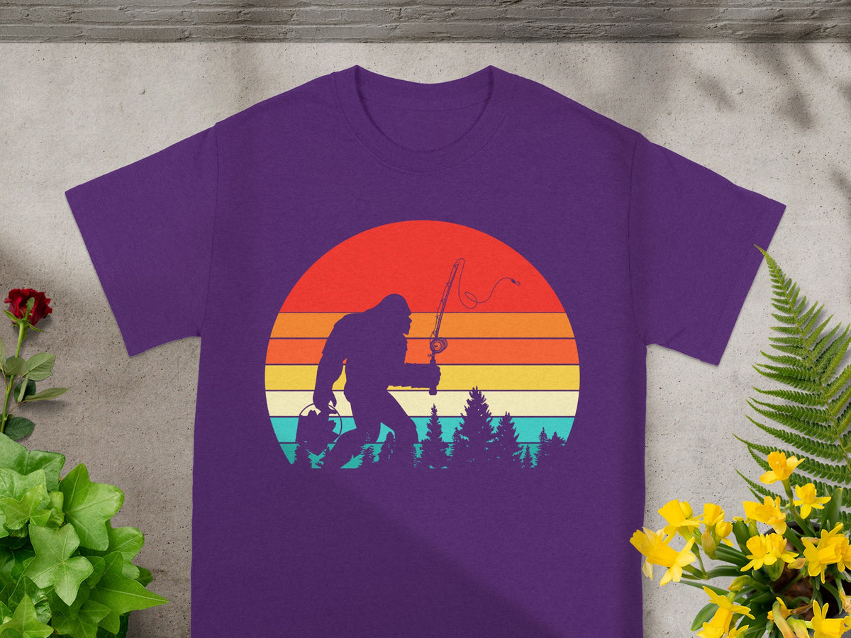 Bigfoot silhouette fishing against a retro striped sunset on a purple t-shirt.