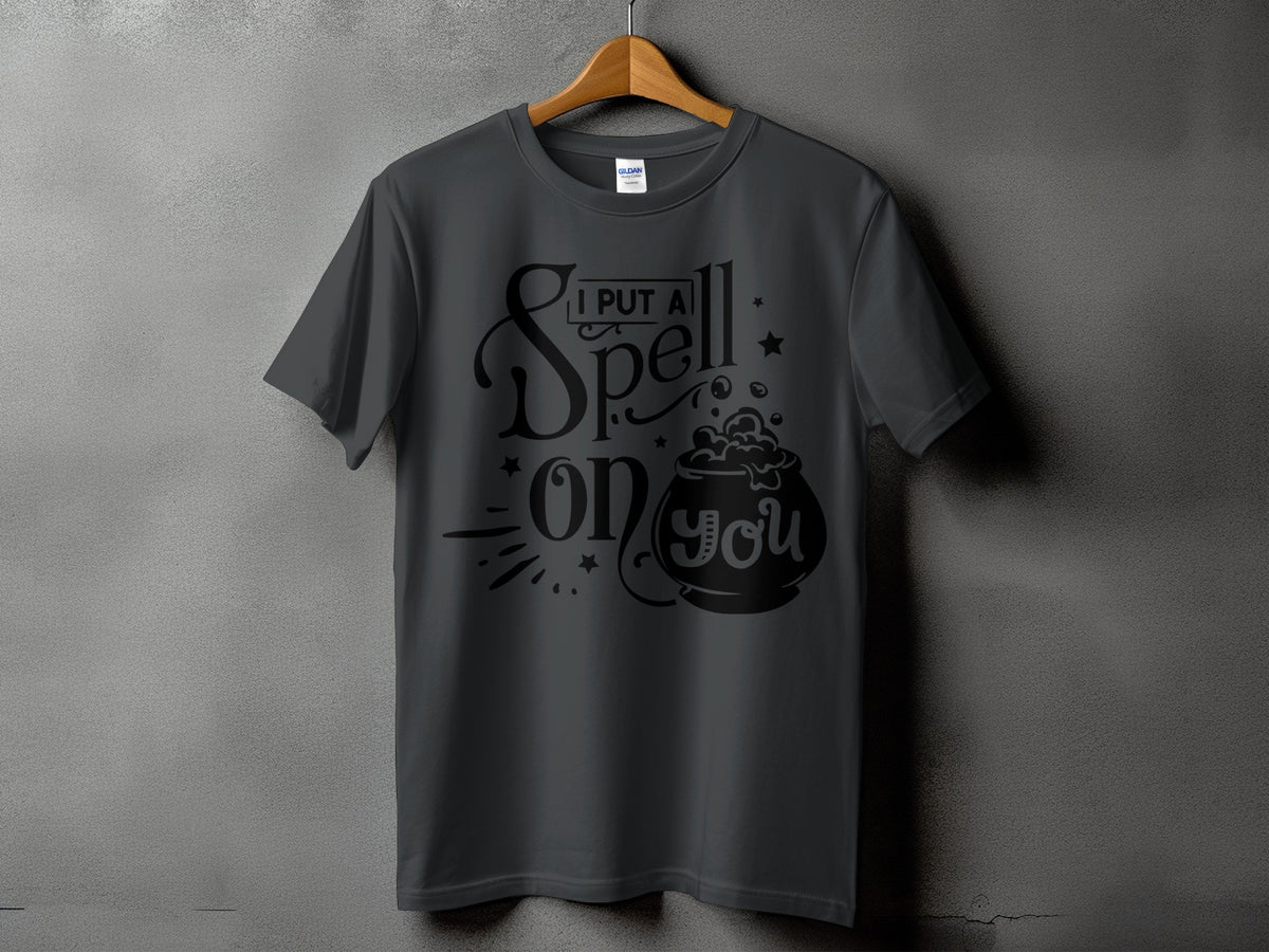 Dark gray t-shirt with "I PUT A Spell on you" text and cauldron graphic.