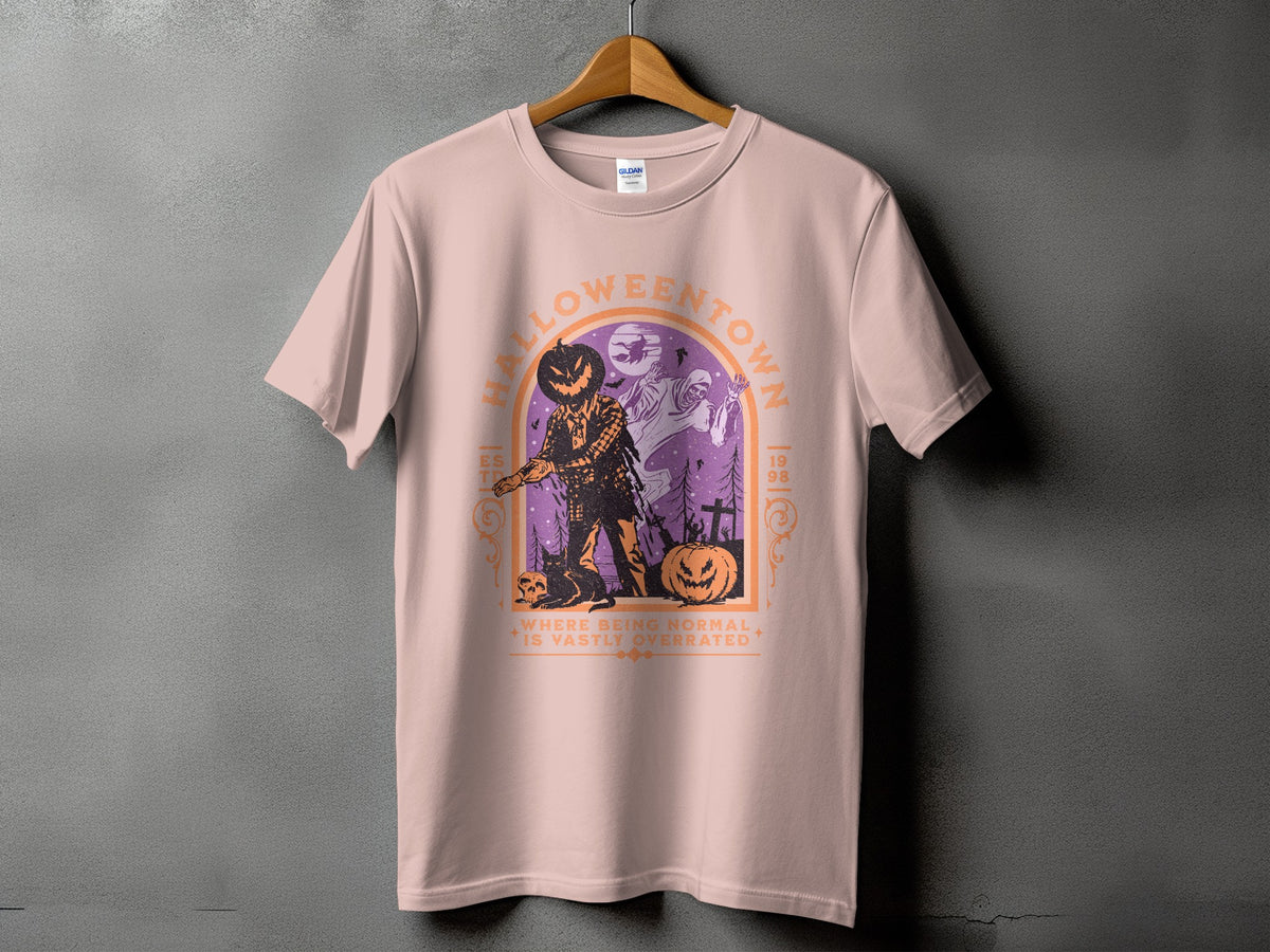 Pink t-shirt with "Halloweentown" graphic featuring a scarecrow, ghost, and pumpkins.