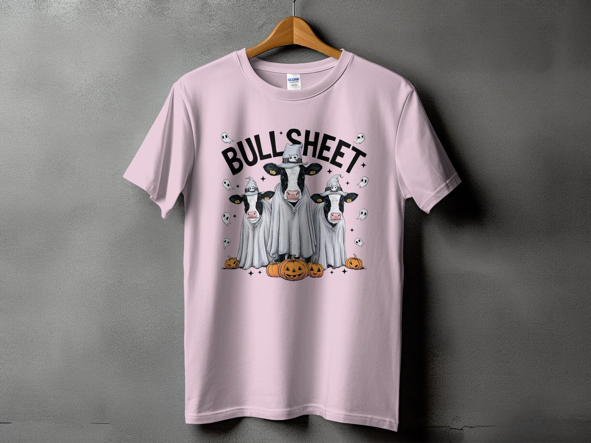Pink t-shirt with three cows dressed as ghosts with pumpkins and the text "BULL SHEET".