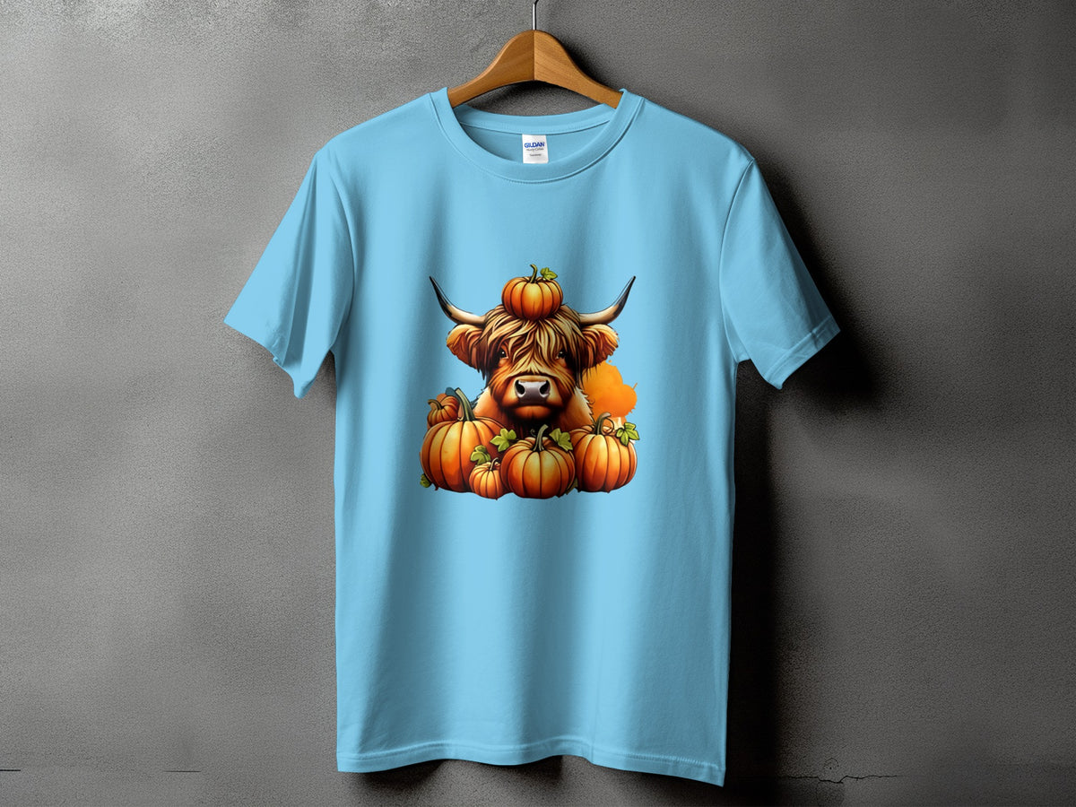 Light blue t-shirt featuring a Highland cow illustration with pumpkins.