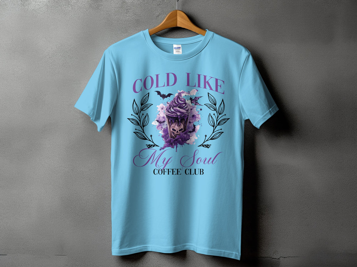 Light blue t-shirt with "COLD LIKE My Soul COFFEE CLUB" text and a spooky latte design.