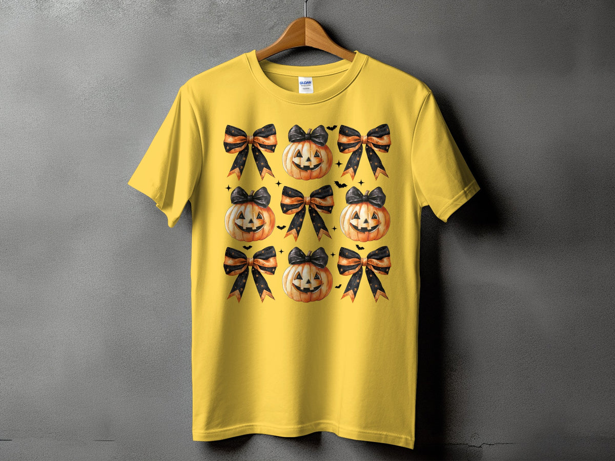 Yellow t-shirt with a repeating pattern of jack-o'-lanterns and black and orange striped bows.