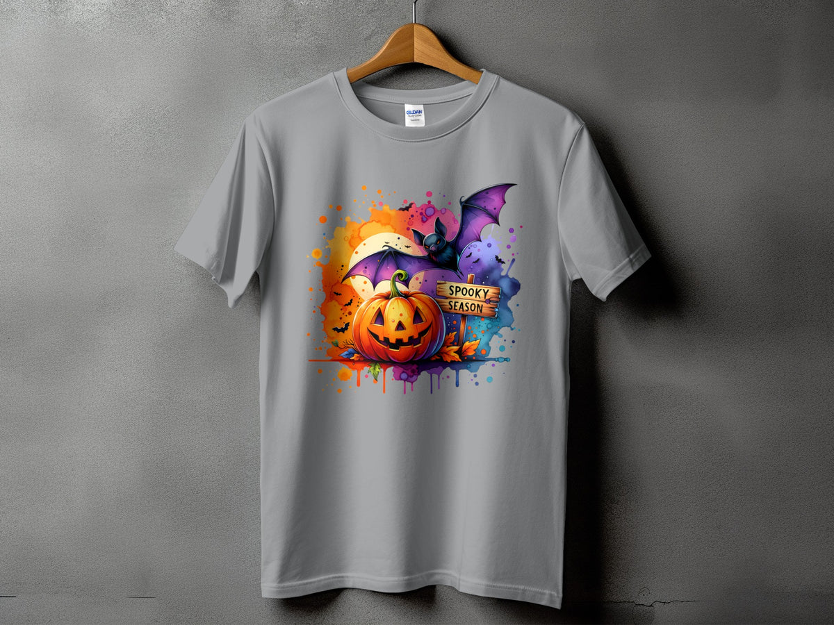 Gray t-shirt with watercolor Halloween design featuring a jack-o'-lantern, bat, and "Spooky Season" sign.