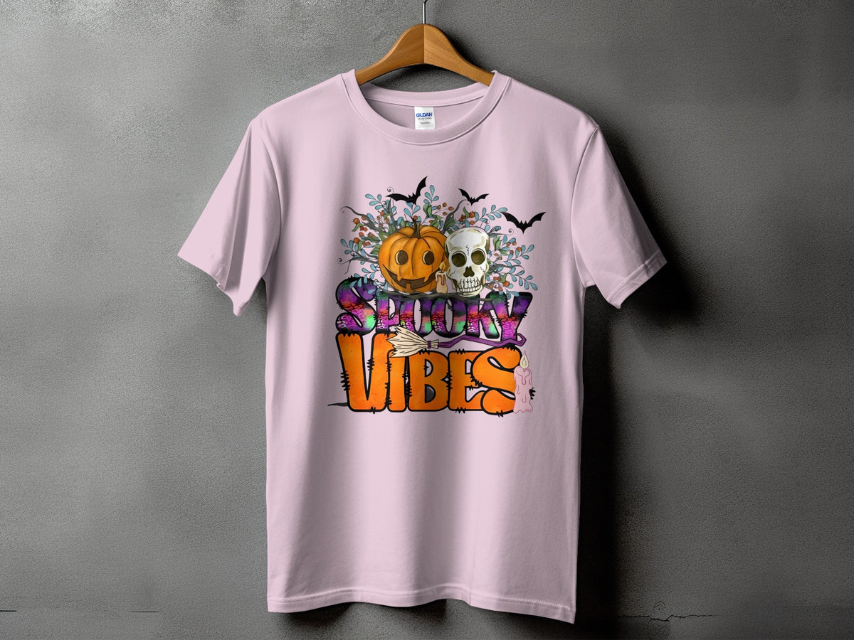 Pink t-shirt with Halloween graphic: pumpkin, skull, bats, and "Spooky Vibes" text.