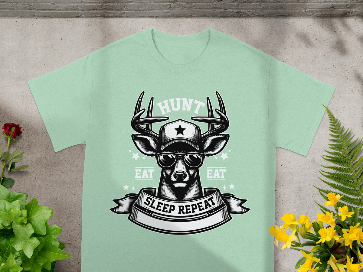 Light green t-shirt with deer wearing sunglasses and a cap, "HUNT" and "EAT SLEEP REPEAT" text.