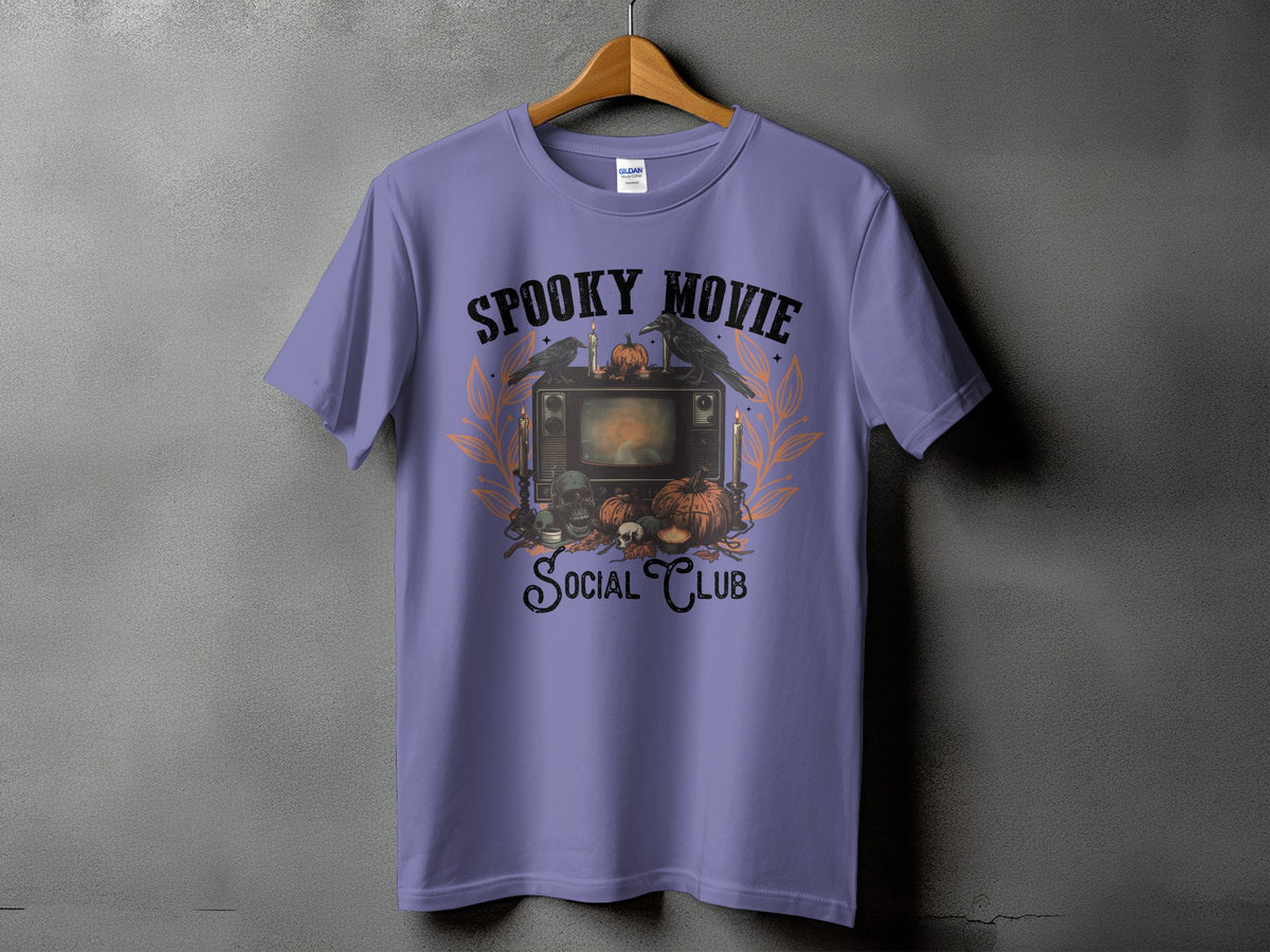 Purple t-shirt with "Spooky Movie Social Club" graphic featuring a retro TV, crows, skulls, and pumpkins.