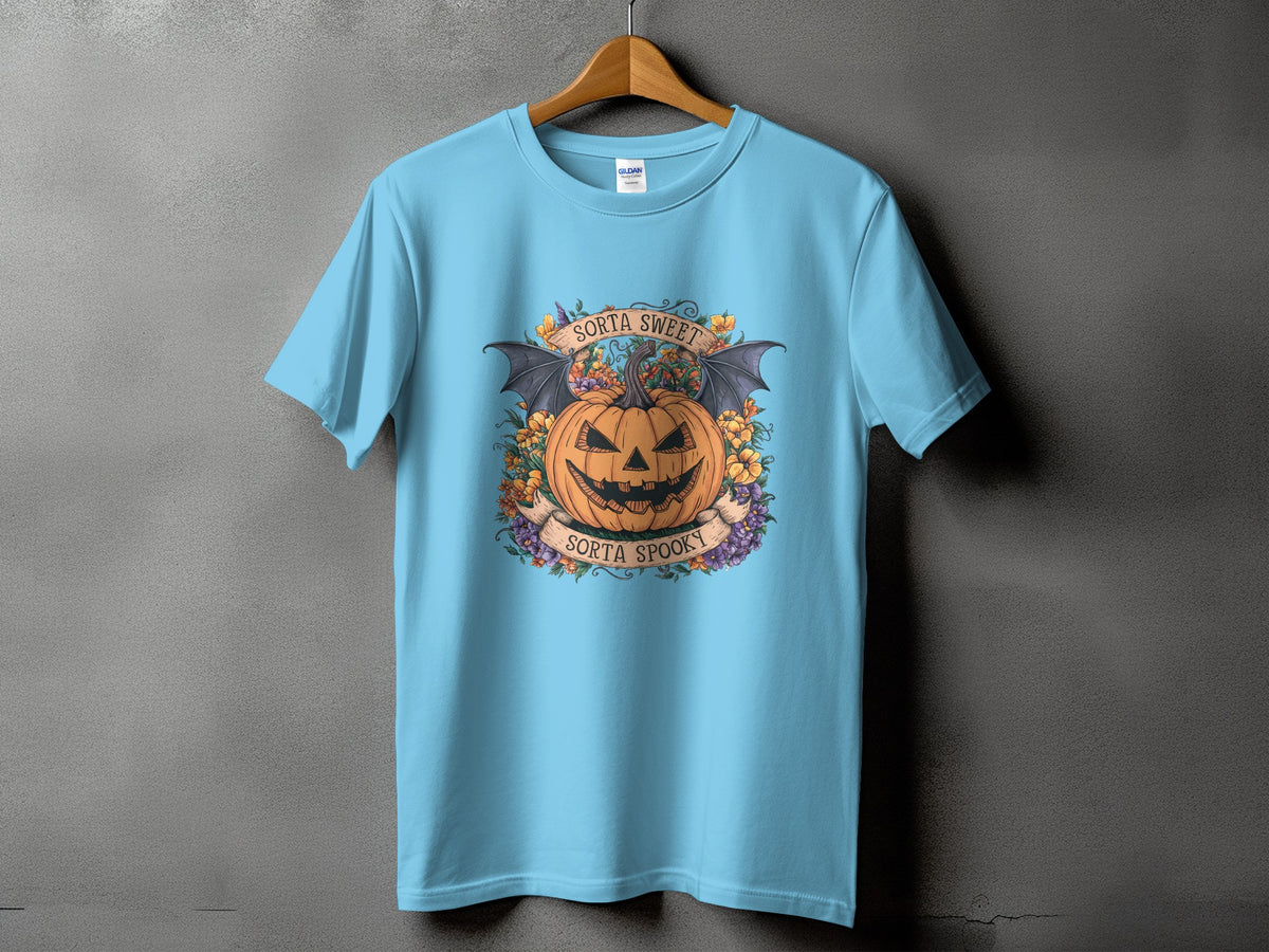 Light blue t-shirt with Halloween graphic of a pumpkin with bat wings, flowers, and text.