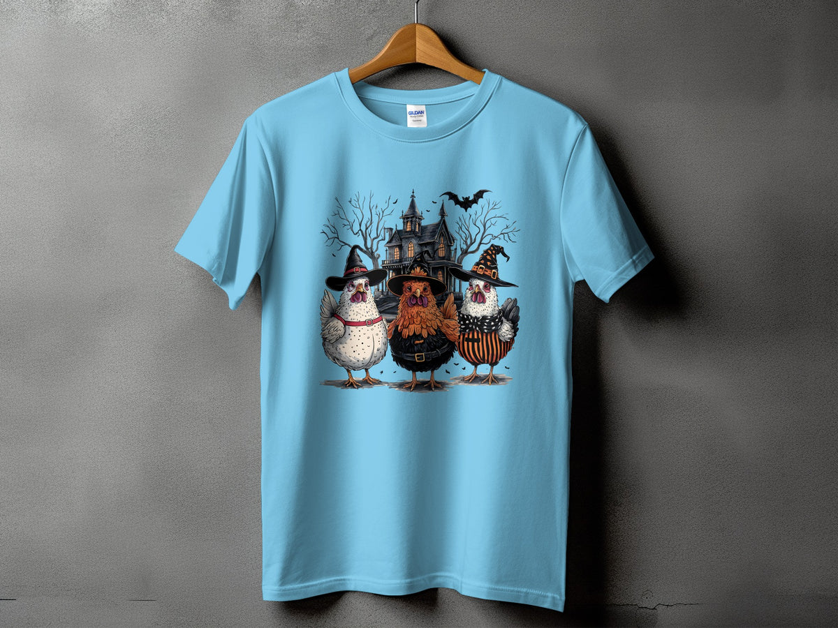 Light blue t-shirt with three chickens in witch hats and costumes.