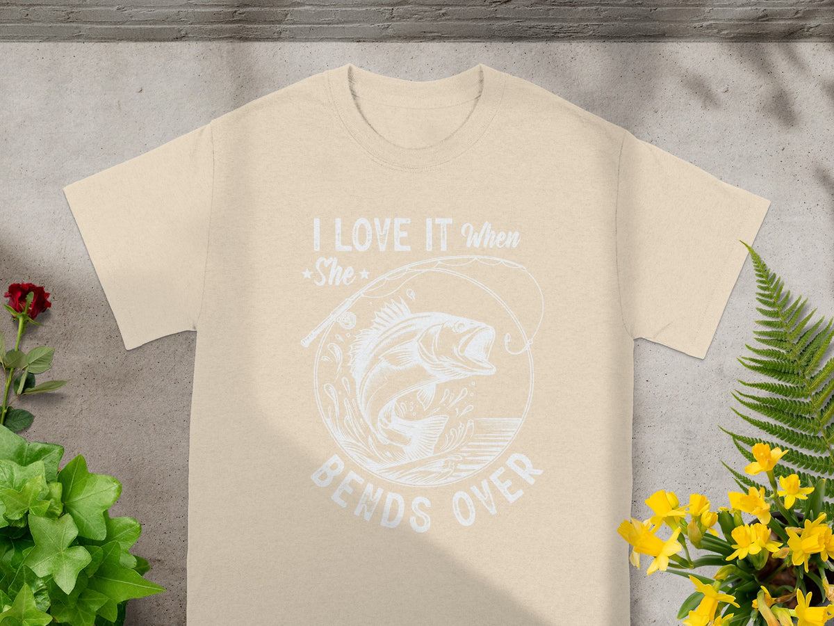 Beige t-shirt with white graphic: "I love it when she bends over" and fishing graphic.