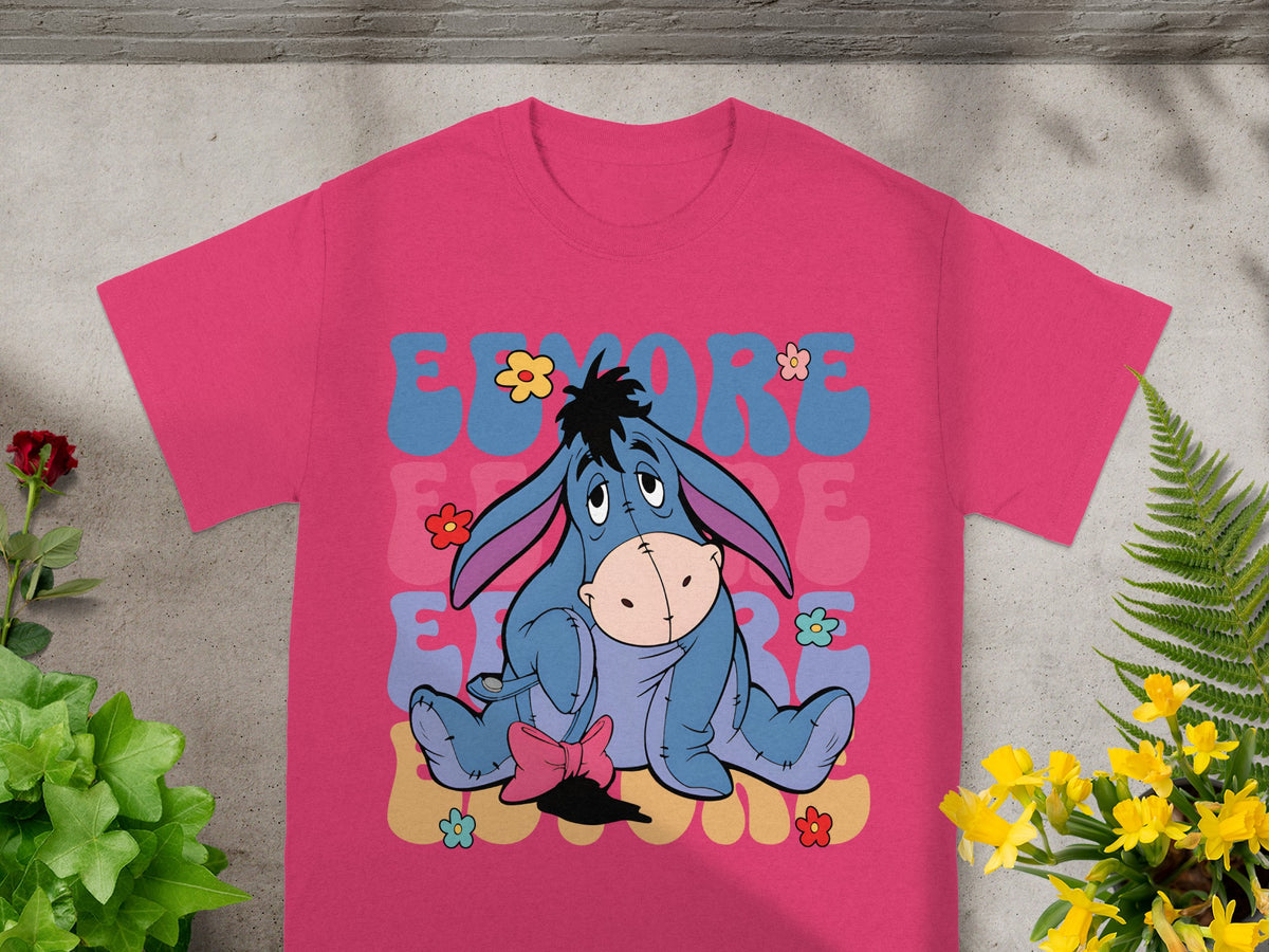Eeyore character with flowers on a pink t-shirt, "EEYORE" text design.