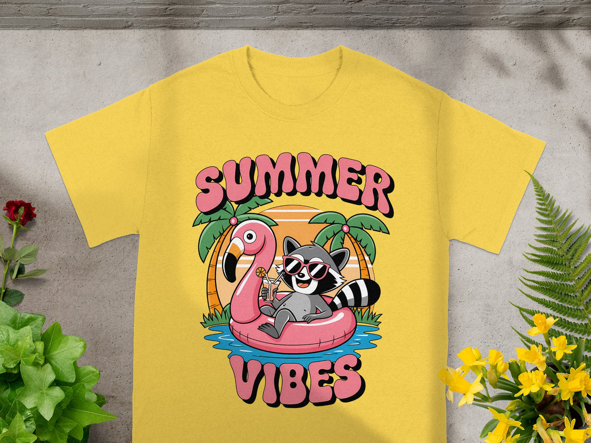 Yellow t-shirt with cartoon raccoon on flamingo float, "SUMMER VIBES" text.