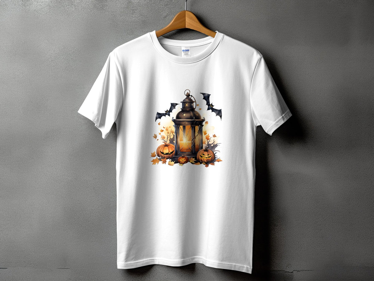 White t-shirt with Halloween graphic of lantern, pumpkins, bats, and autumn leaves.