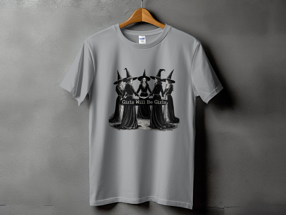 Gray t-shirt with a graphic of five witches in a circle, text reads "Girls Will Be Girls."