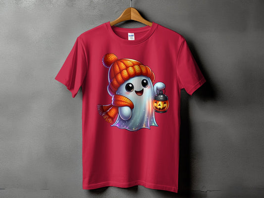 Pink t-shirt featuring a cartoon ghost wearing a beanie and scarf, holding a pumpkin lantern.