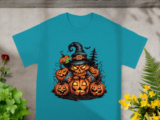 Jack-o'-lantern witch surrounded by pumpkins and bats on a teal t-shirt.
