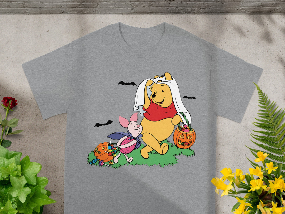 Winnie the Pooh and Piglet in Halloween costumes with candy and pumpkins.