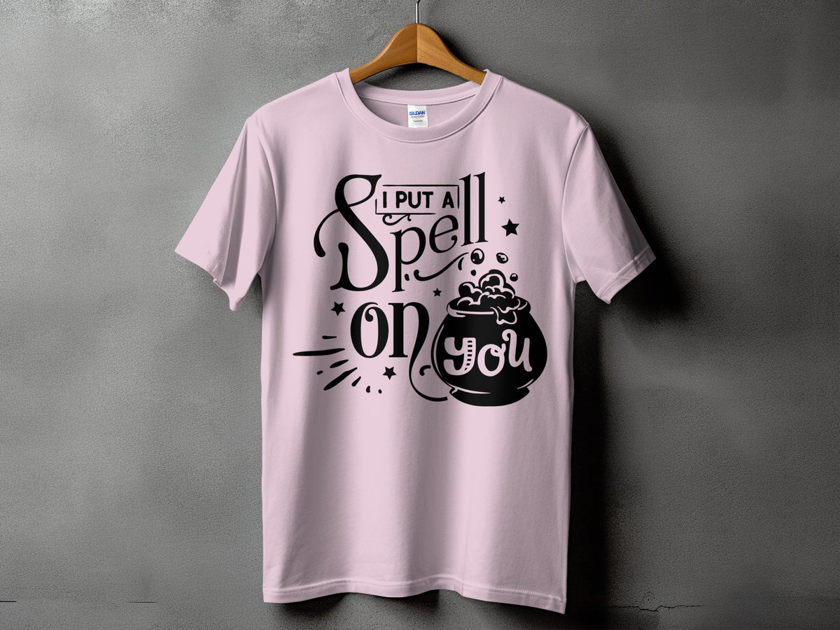 Pink t-shirt with black graphic saying "I Put A Spell On You" and a cauldron.