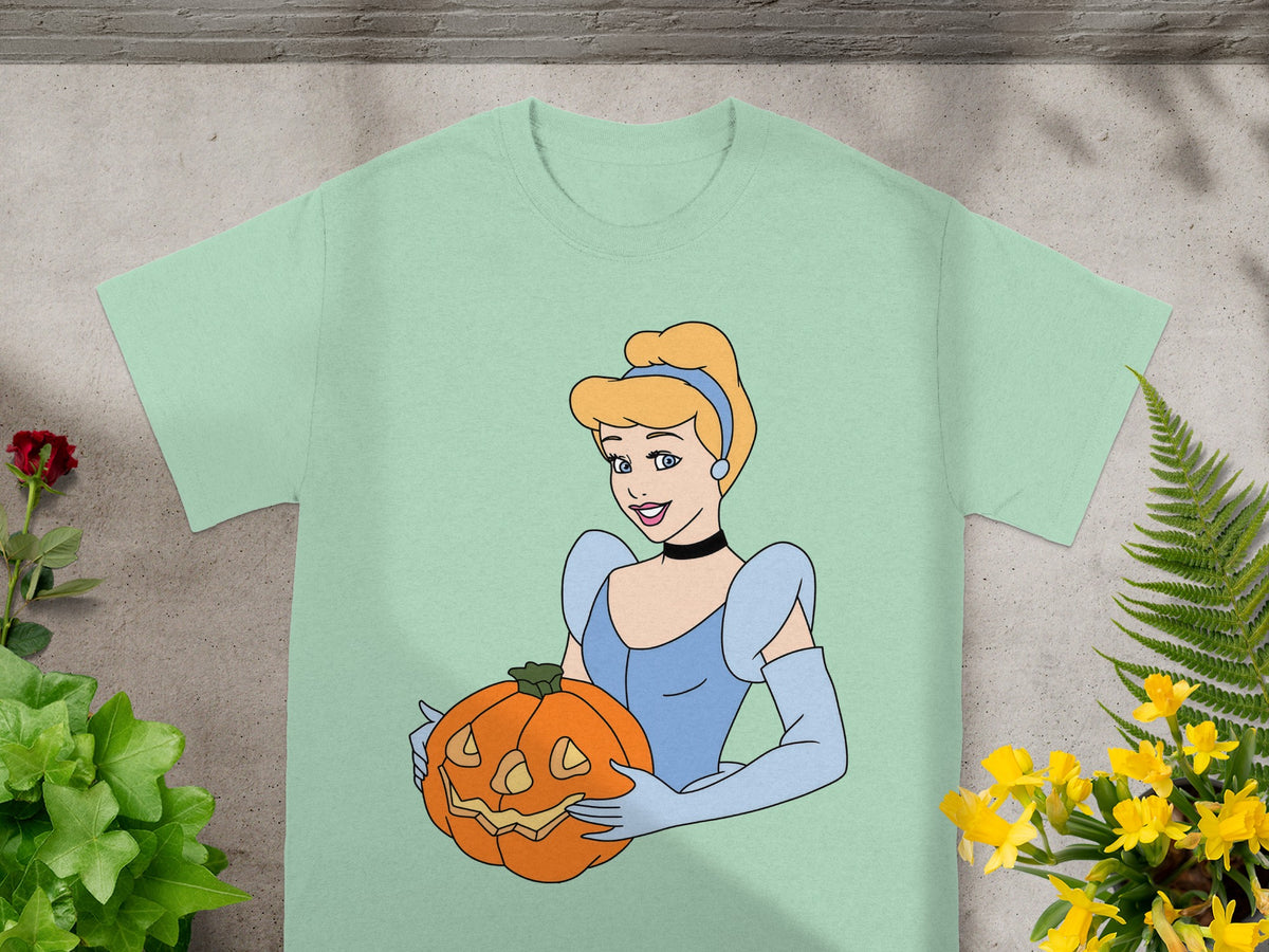 Cinderella holding a carved jack-o'-lantern on a light green t-shirt.