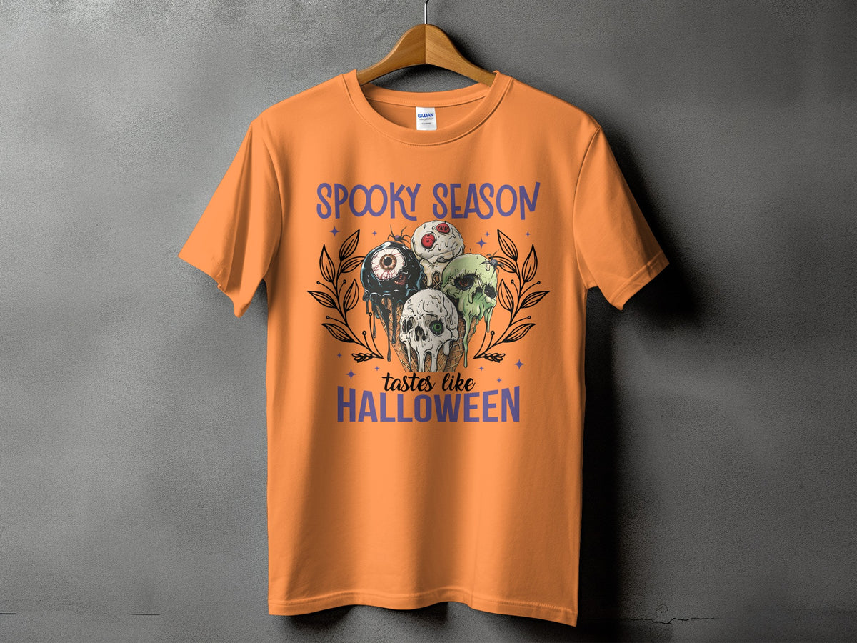 Orange t-shirt with "Spooky Season Tastes Like Halloween" text and creepy ice cream graphic.