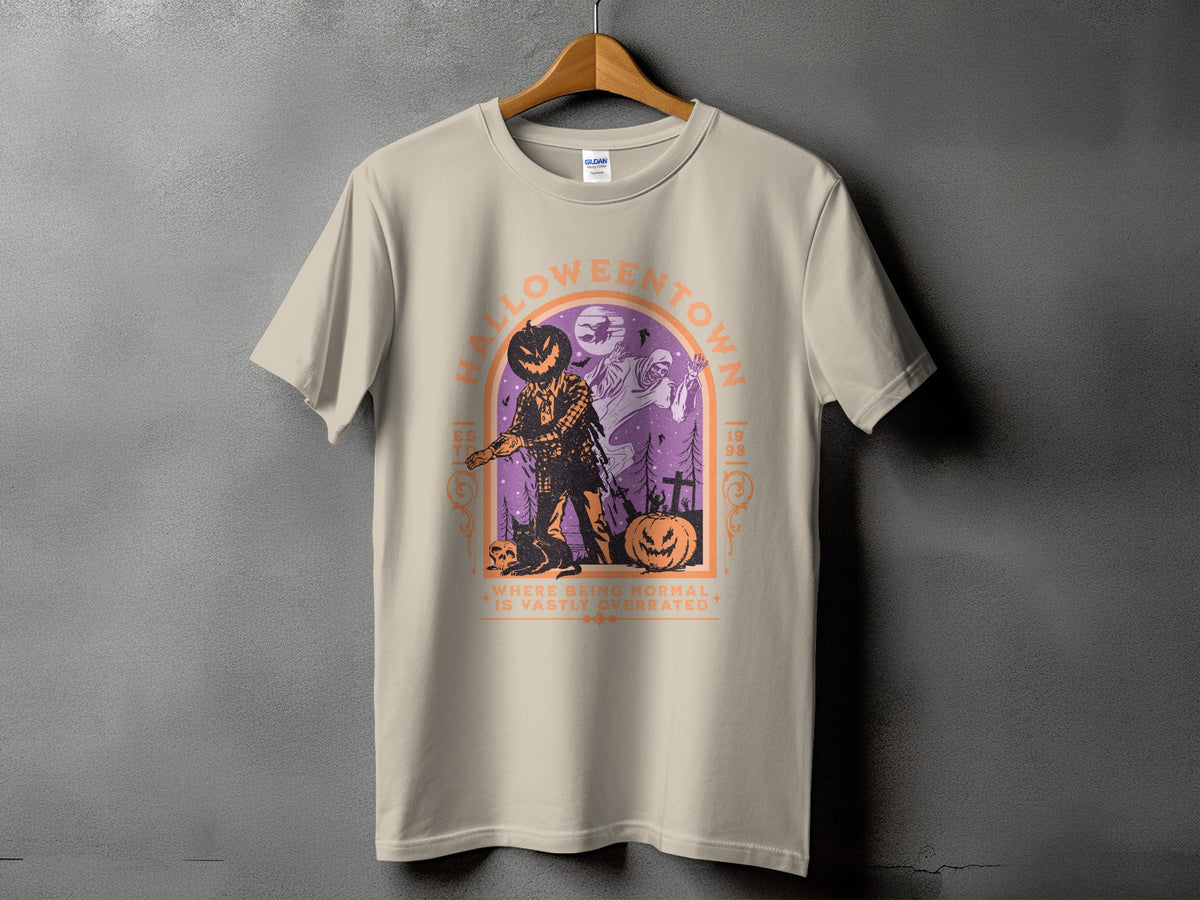 Light tan t-shirt with a graphic of a jack-o'-lantern man and ghosts in a spooky scene.